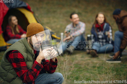 Image of Group of friends on a camping or hiking trip in autumn day