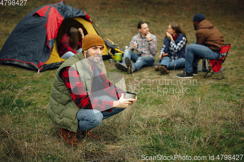 Image of Group of friends on a camping or hiking trip in autumn day