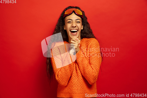 Image of African-american young woman\'s portrait in ski mask on red background