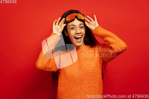 Image of African-american young woman\'s portrait in ski mask on red background