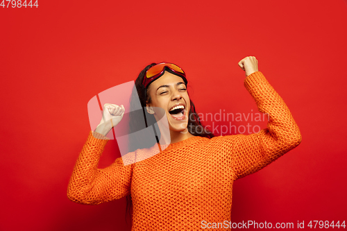 Image of African-american young woman\'s portrait in ski mask on red background