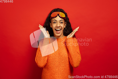 Image of African-american young woman\'s portrait in ski mask on red background