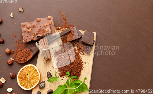 Image of chocolate with hazelnuts, cocoa beans and powder