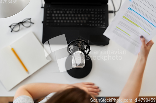 Image of woman with microphone recording podcast at studio