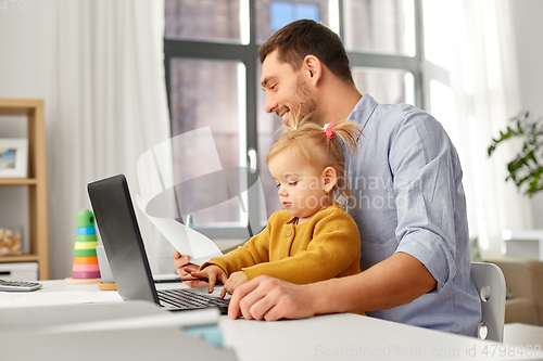 Image of working father with baby daughter at home office