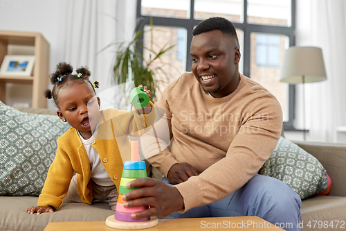 Image of african family playing with baby daughter at home