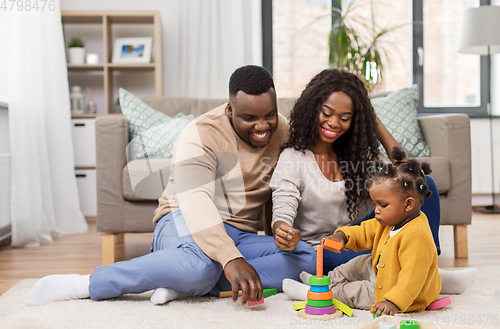 Image of african family playing with baby daughter at home