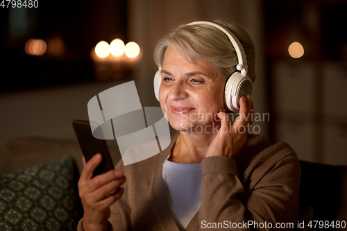 Image of senior woman in headphones listening to music