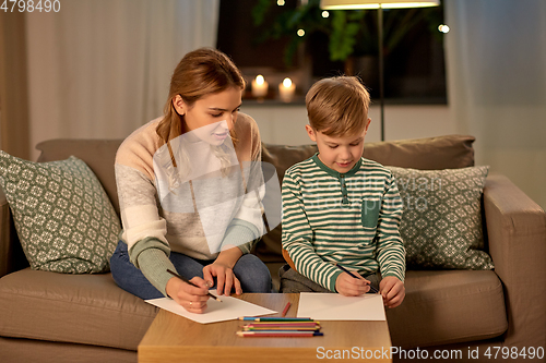 Image of mother and son with pencils drawing at home