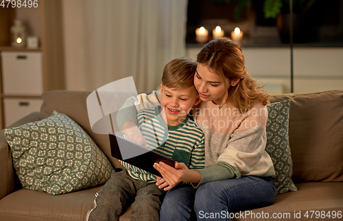 Image of mother and son using tablet computer at home