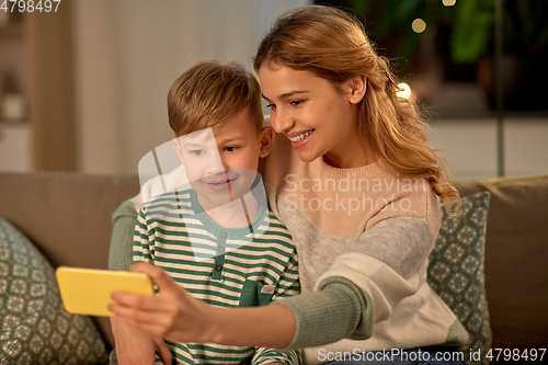 Image of mother and son taking selfie by smartphone at home