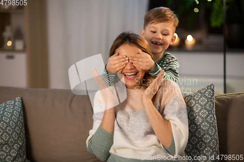 Image of happy smiling mother playing with her son at home