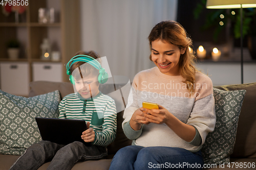 Image of mother and son using gadgets at home