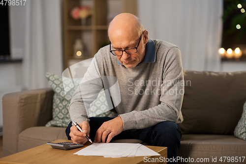 Image of senior man with bills and calculator at home