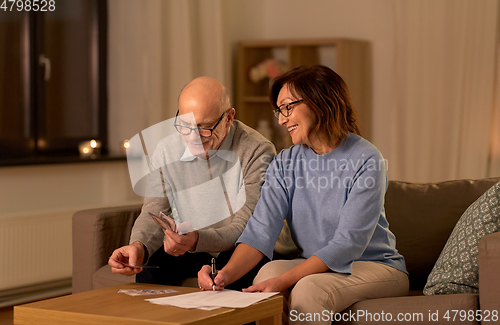 Image of senior couple with bills counting money at home