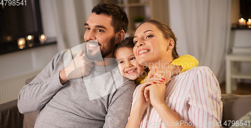 Image of portrait of happy family sitting on sofa at home