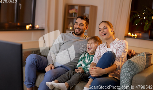 Image of happy family watching tv at home at night