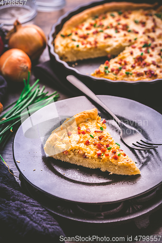 Image of Piece of homemade onion tart or pie with bacon and chives