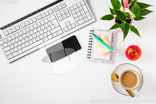 Image of Workplace and office desk with coffee, apple, laptop, headset and smarthpone