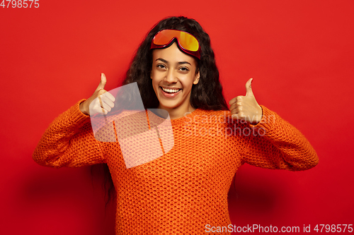 Image of African-american young woman\'s portrait in ski mask on red background