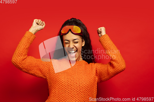 Image of African-american young woman\'s portrait in ski mask on red background