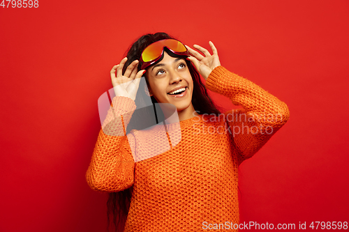 Image of African-american young woman\'s portrait in ski mask on red background