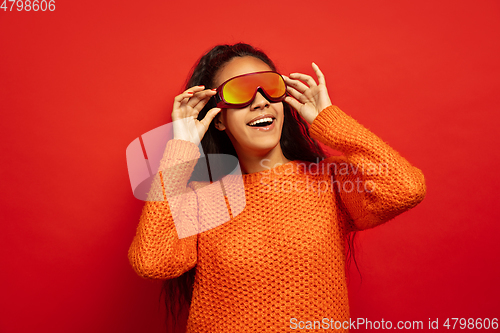 Image of African-american young woman\'s portrait in ski mask on red background