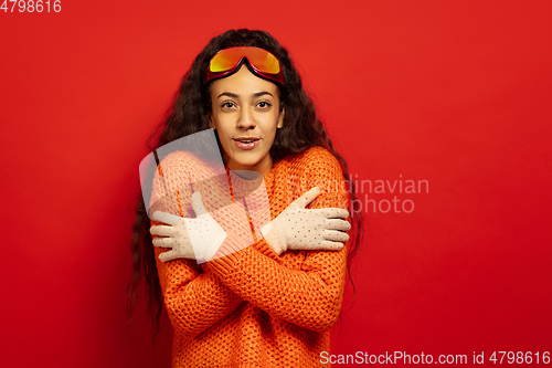 Image of African-american young woman\'s portrait in ski mask on red background
