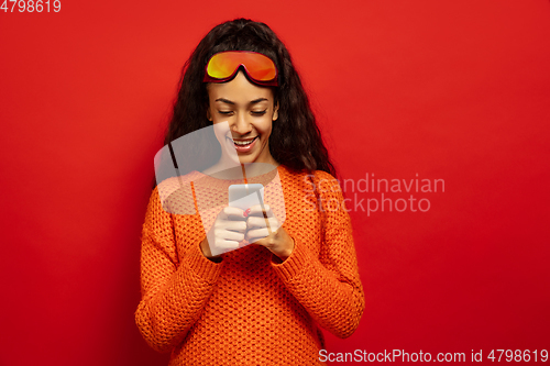 Image of African-american young woman\'s portrait in ski mask on red background