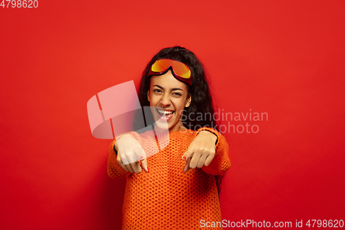 Image of African-american young woman\'s portrait in ski mask on red background