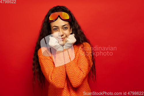 Image of African-american young woman\'s portrait in ski mask on red background
