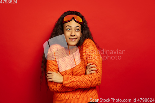 Image of African-american young woman\'s portrait in ski mask on red background