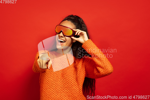 Image of African-american young woman\'s portrait in ski mask on red background