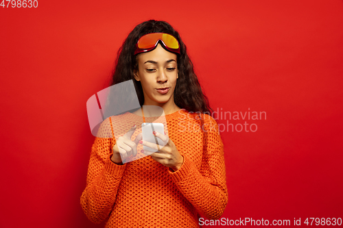 Image of African-american young woman\'s portrait in ski mask on red background