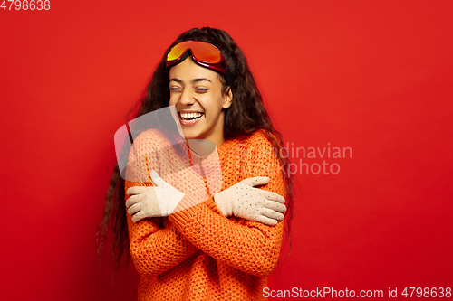 Image of African-american young woman\'s portrait in ski mask on red background