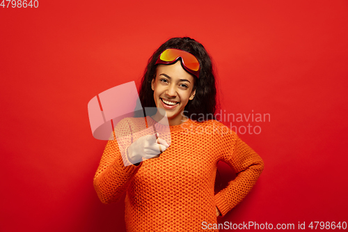 Image of African-american young woman\'s portrait in ski mask on red background