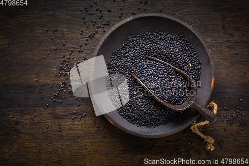 Image of Beluga lentils in bowl on dark wooden background