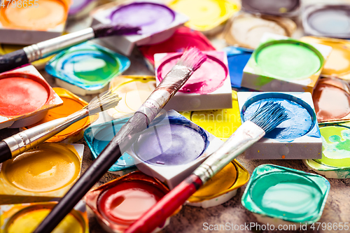 Image of Set of watercolor paints and paintbrushes for painting closeup. 