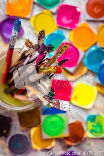 Image of Set of watercolor paints and paintbrushes for painting closeup. 