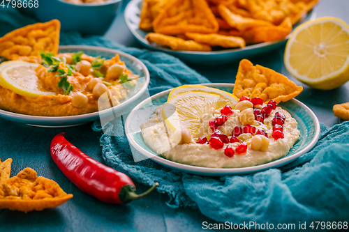 Image of Homemade spicy humus with pomegranate seeds, chilli and chickpeas tortilla chips