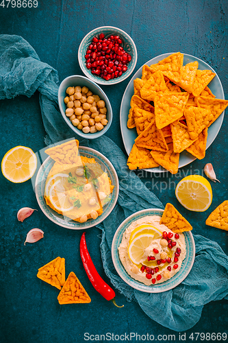 Image of Homemade spicy humus with pomegranate seeds, chilli and chickpeas tortilla chips