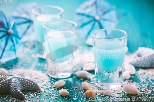 Image of Blue shots for summer with seashells on blue background