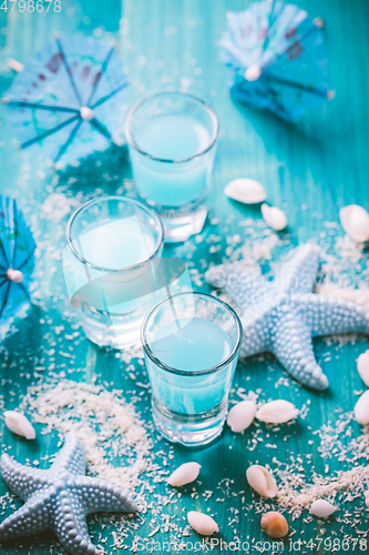 Image of Blue shots for summer with seashells on blue background