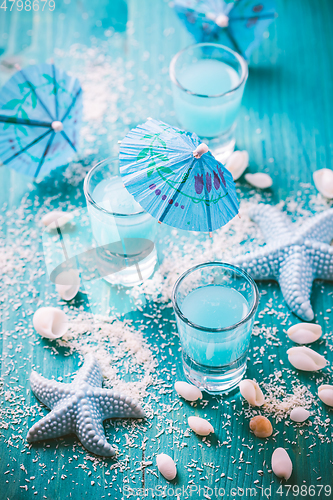 Image of Blue shots for summer with seashells on blue background