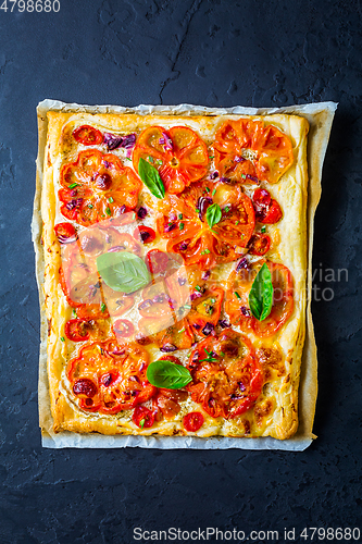 Image of Vegetarian tomato tart or puffed pizza with herbs