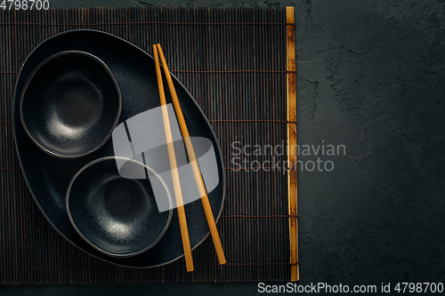 Image of Pottery bowls or ceramics in blacke tone with chopsticks