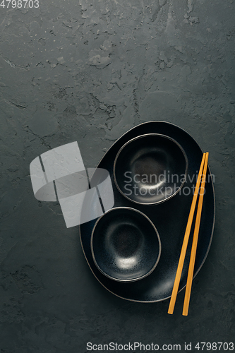 Image of Pottery bowls or ceramics in blacke tone with chopsticks