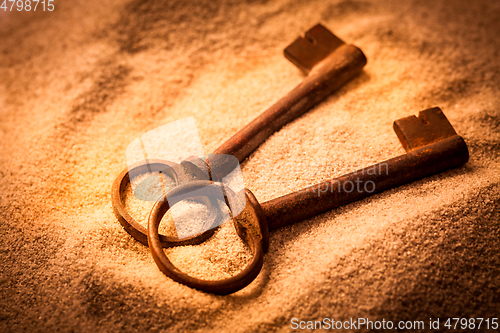 Image of Two old rusty keys in sand