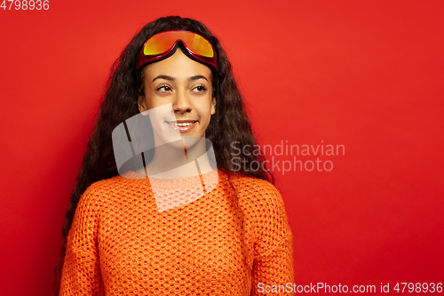 Image of African-american young woman\'s portrait in ski mask on red background
