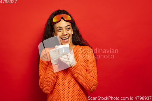 Image of African-american young woman\'s portrait in ski mask on red background